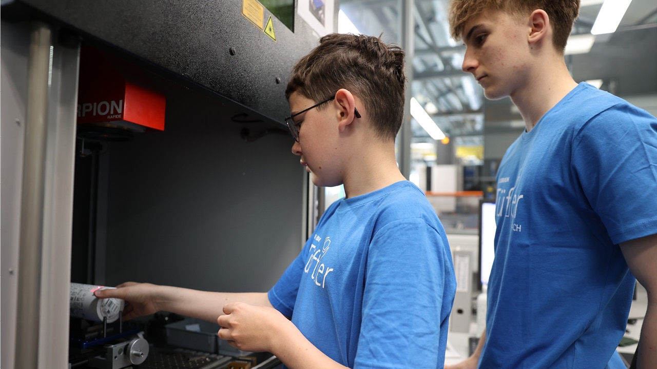 Junge bei der Laserbeschriftung einer Wasserflasche