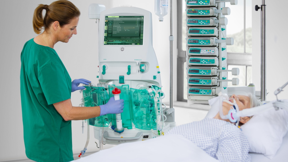 Le spécialiste utilise l'appareil de dialyse et à côté de lui, une patiente est allongée sur le lit
