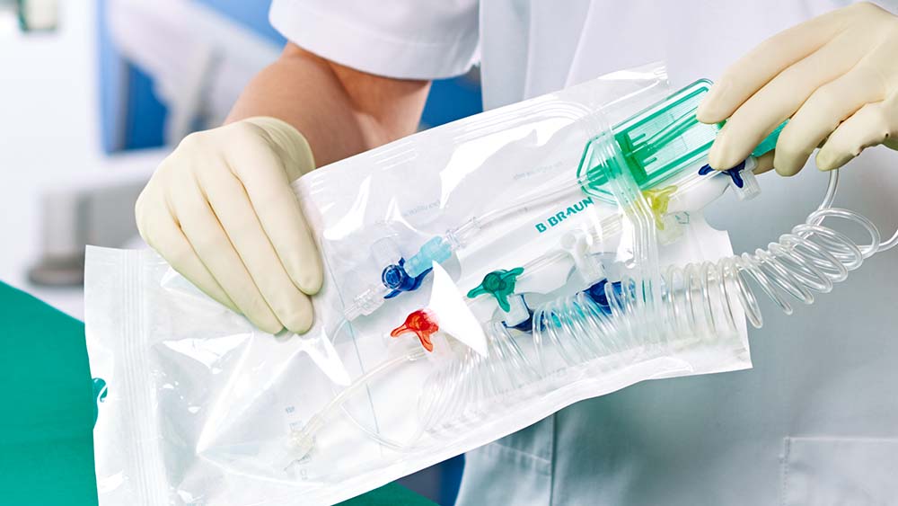 Un professionnel de santé est montré en train de retirer un instrument médical préconfiguré B. Braun de ses sachets stériles.