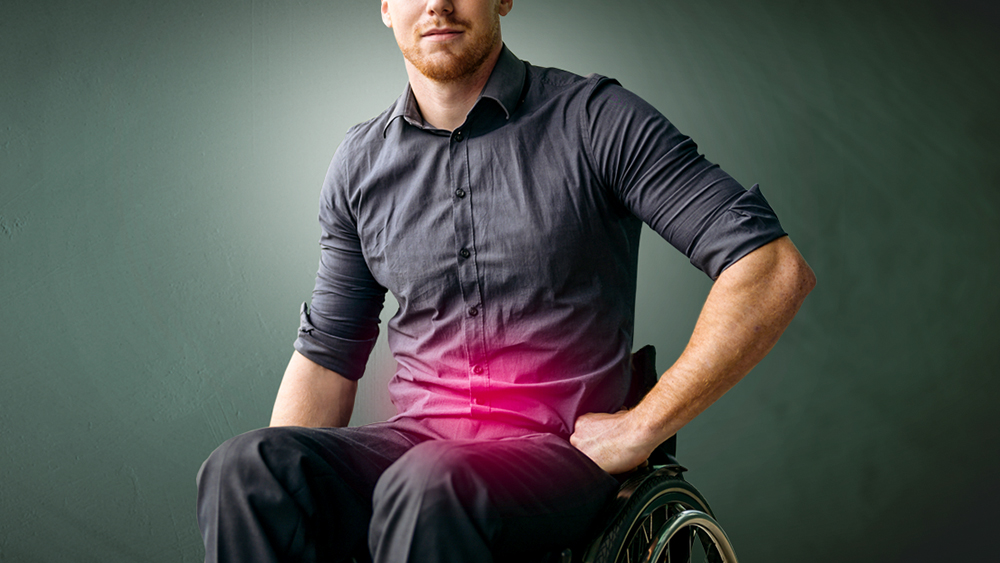 Homme assis en fauteuil roulant, une tache rouge sur l’abdomen indique une douleur dans les voies urinaires