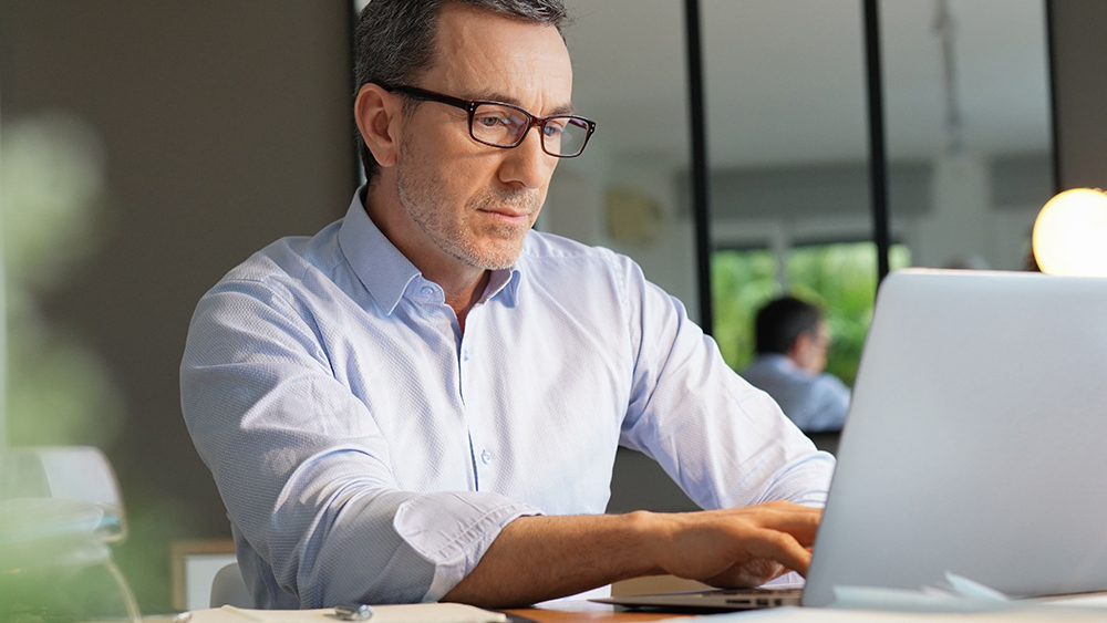 Homme tapant concentré sur un ordinateur portable