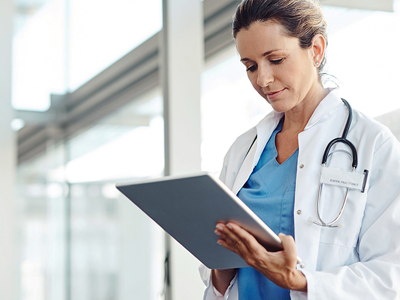 Une médecine regarde une tablette dans ses mains