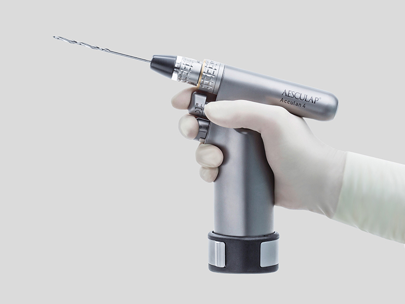 Moteur chirurgical maintenu d’une main avec un gant